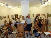 Sala con pittori impegnati a dipingere la propria tela